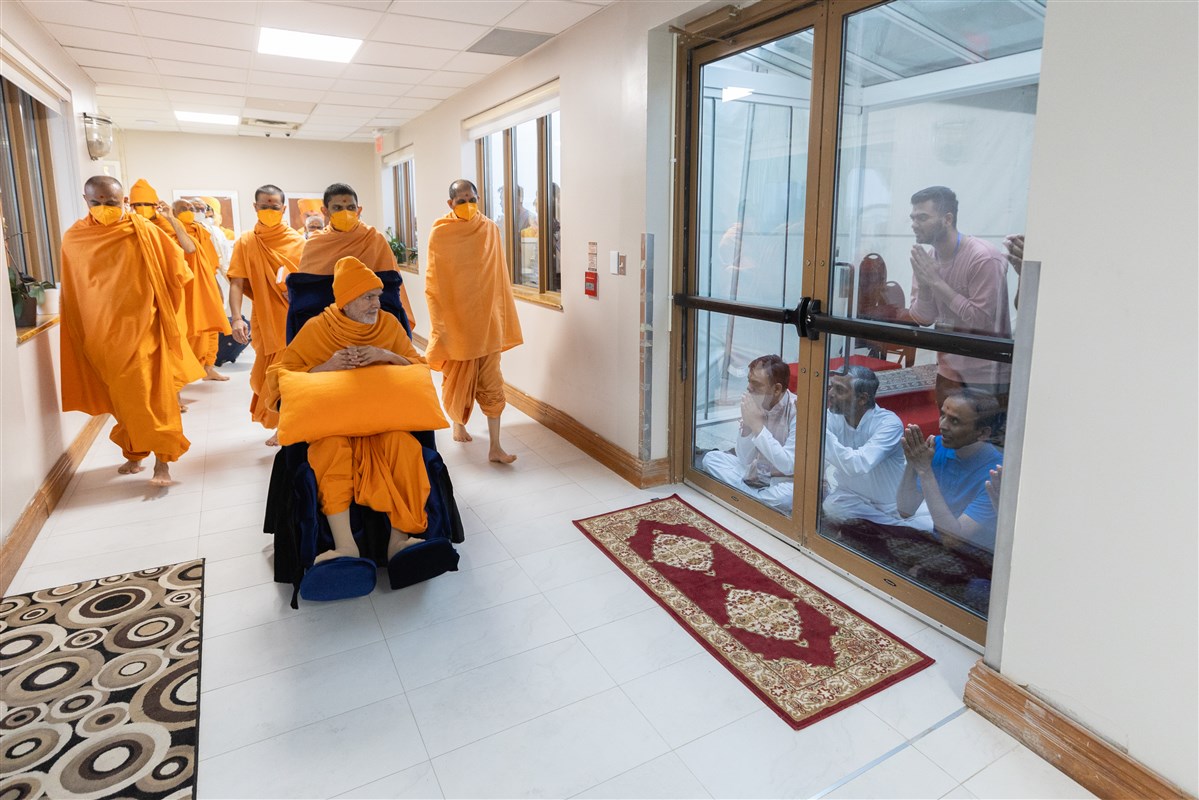 Pujya Mahant Swami Maharaj greets devotees on his way to Thakorji's darshan 
