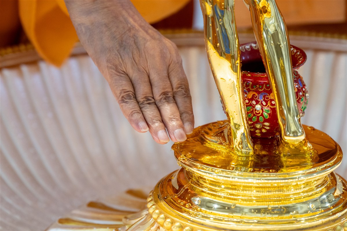 Swamishri reverentially touches the holy feet of Shri Nilkanth Varni
