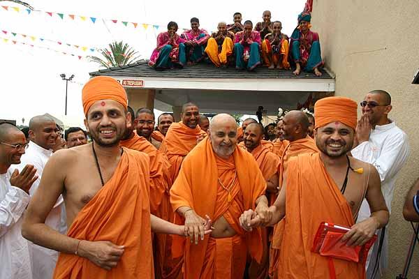 Kishores seated on the roof enthusiatically receive Swamishri 