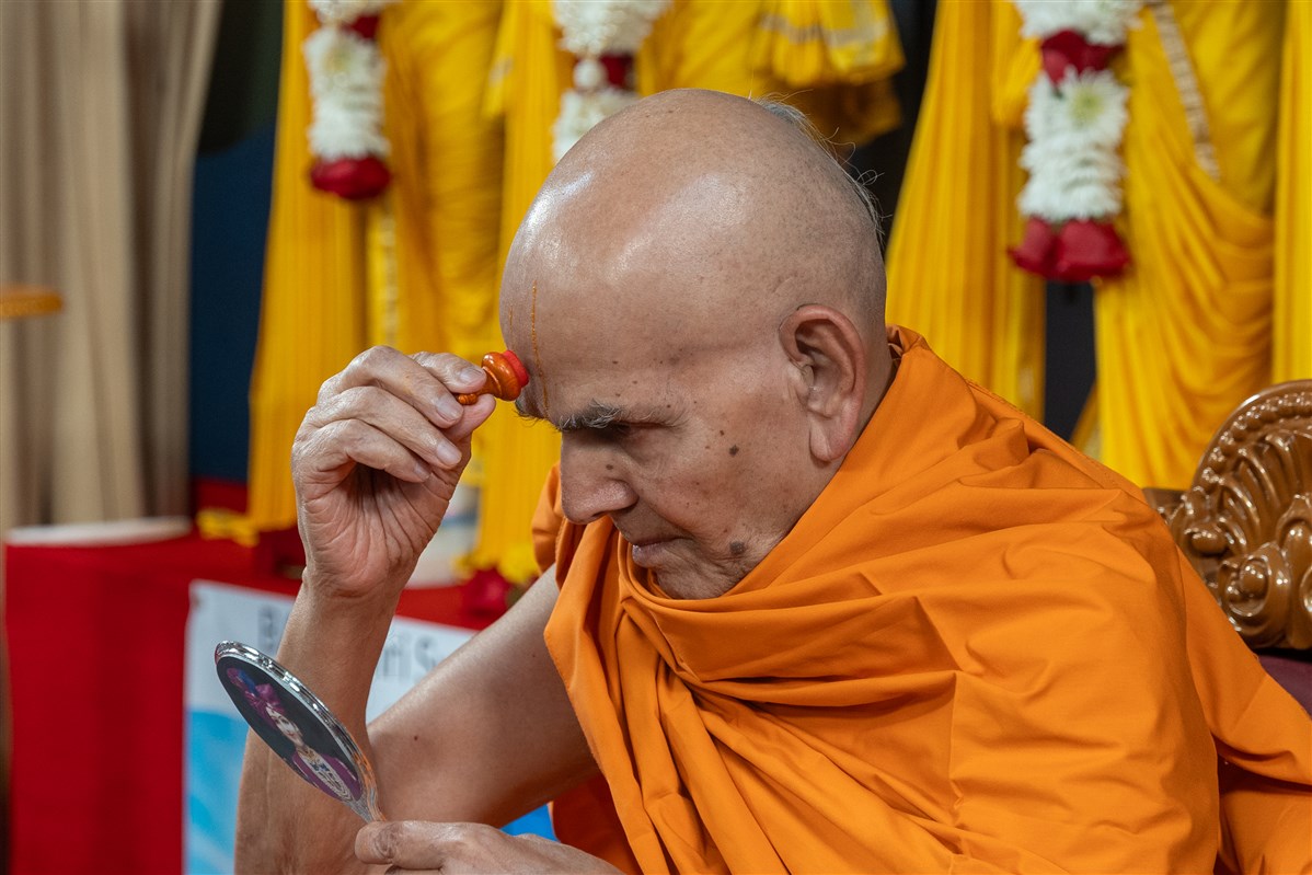 Swamishri applies a chadlo on his forehead