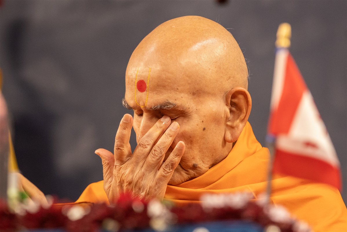 Swamishri reverently touches the holy feet of Bhagwan Swaminarayan and Gunatitanand Swami