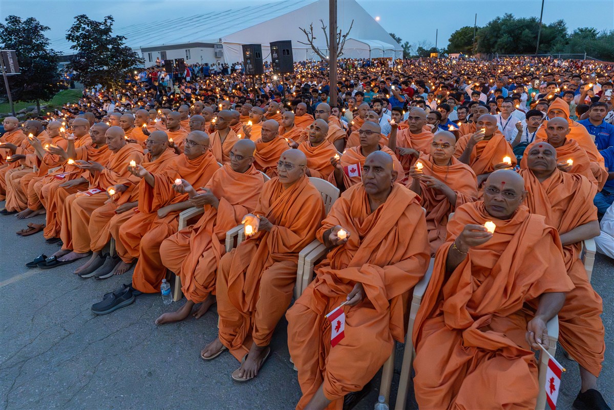 Swamis and devotees perform the evening arti