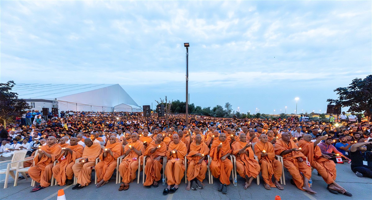 Swamis and devotees perform the evening arti
