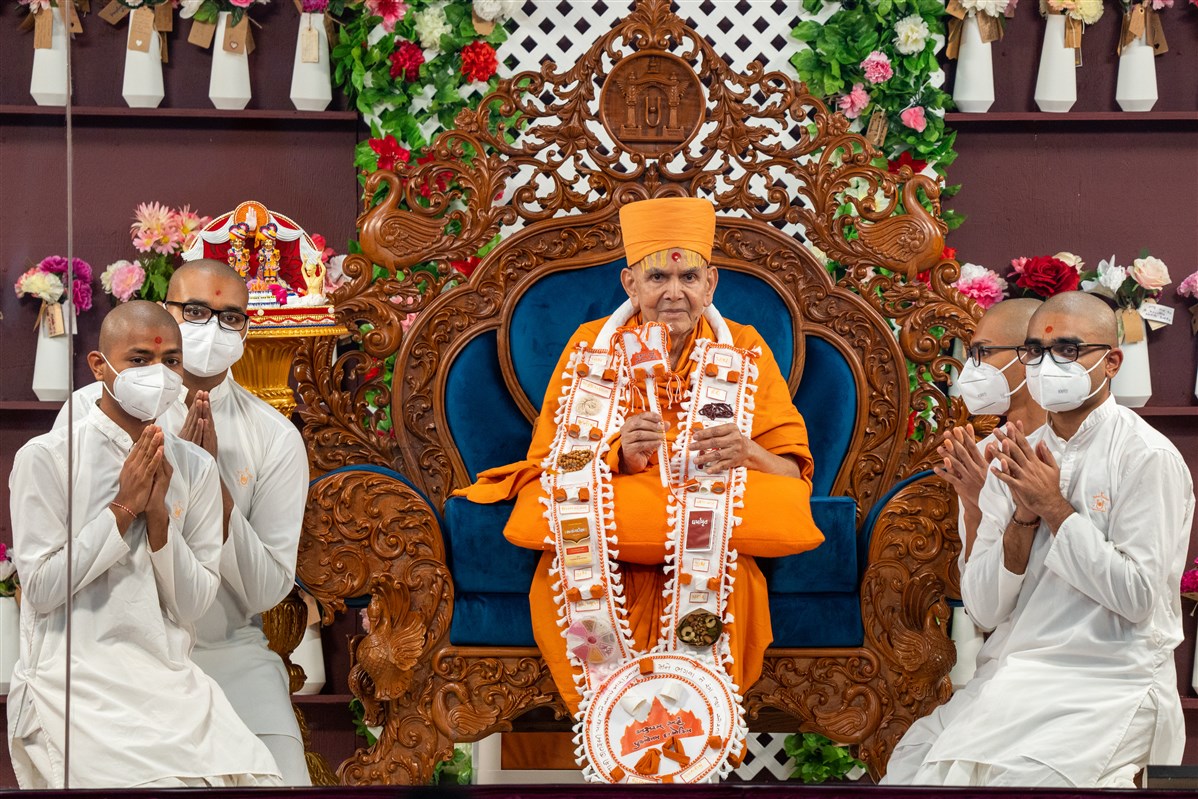 Sadhaks offer Swamishri a decorative garland and chhadi