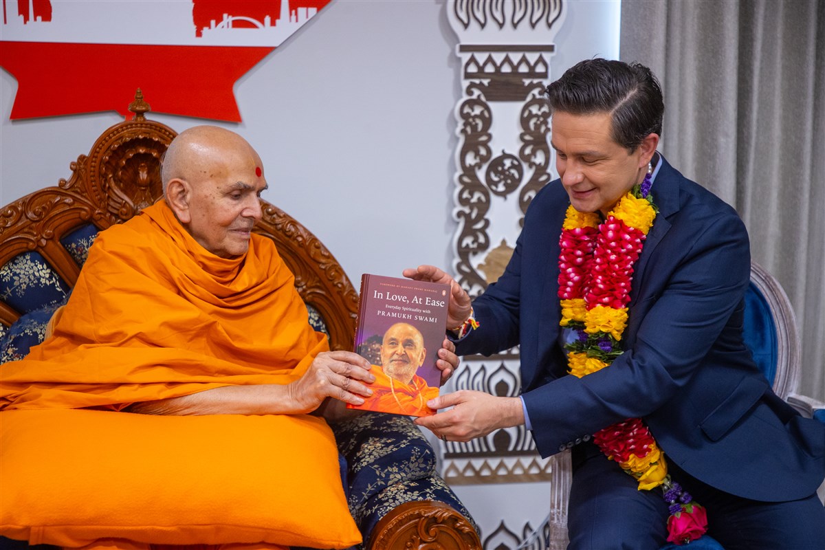HH Mahant Swami Maharaj  presents Hon. Pierre Poilievre with the book 'In Love, At Ease' on Pramukh Swami Maharaj