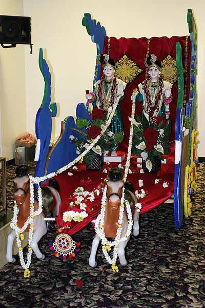Shri Akshar Purushottam Maharaj seated on a chariot in celebration of Rath Yatra 	