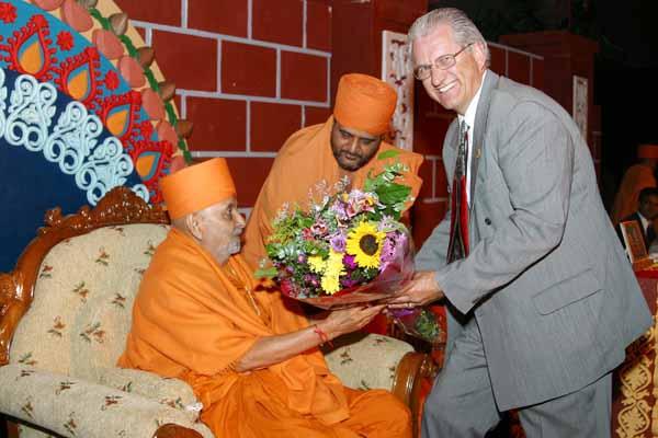 Swamishri is presented with a bouquet by Mr. Gary Larson, Mayor of Chino Hills