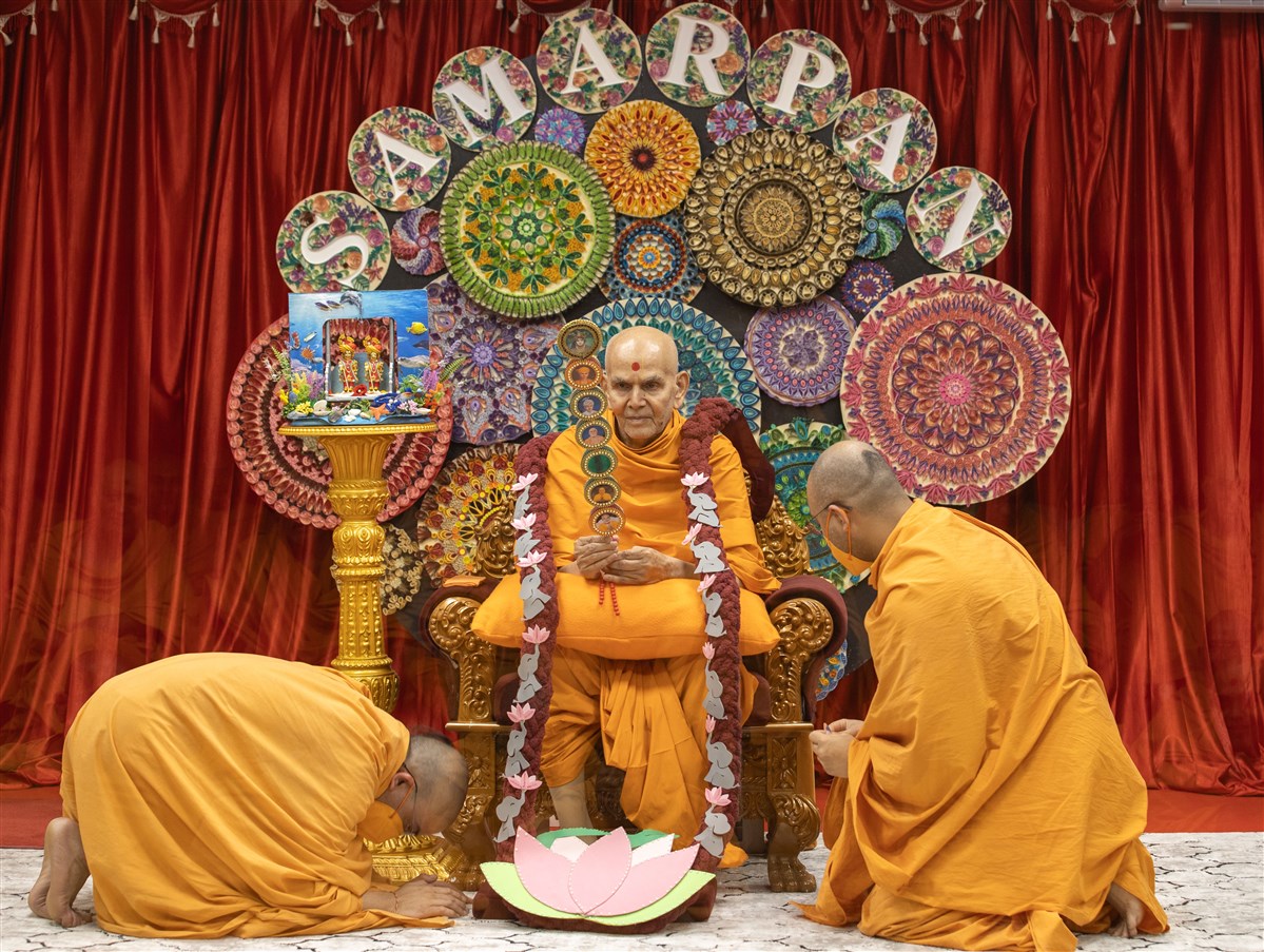 Swamis present Swamishri with a garland and chhadi