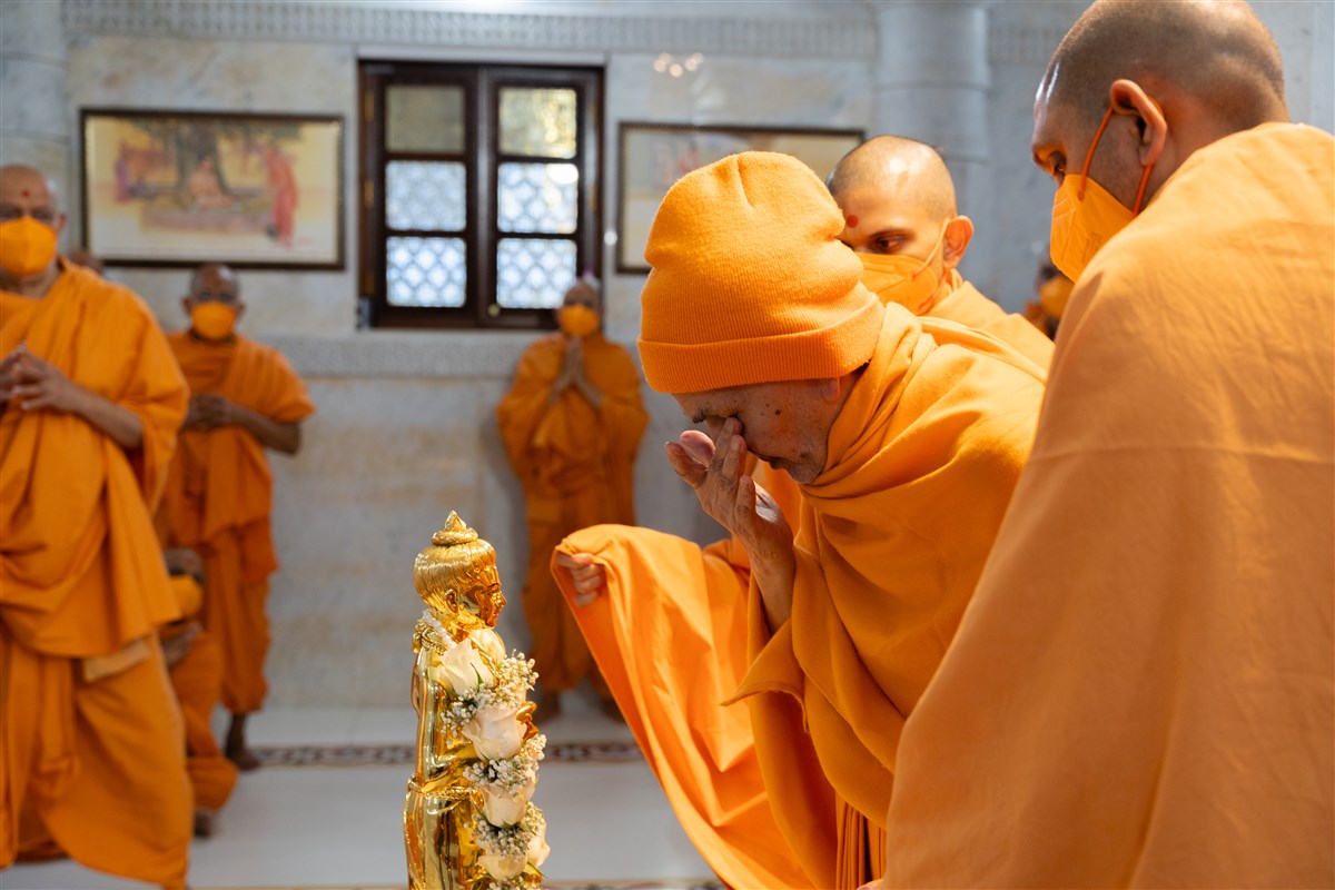 Swamishri devoutly touches the holy feet of Shri Nilkanth Varni