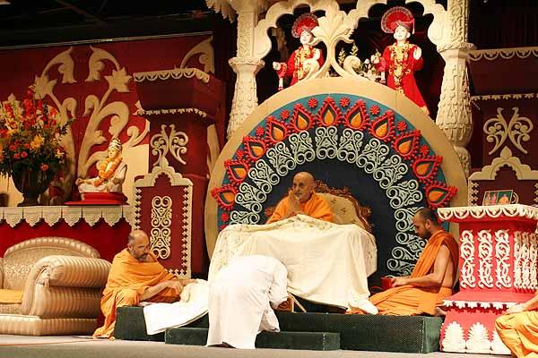 Swamishri is presented with a shawl sent by the New York mandal with the Janmangal Naamavali written on it 