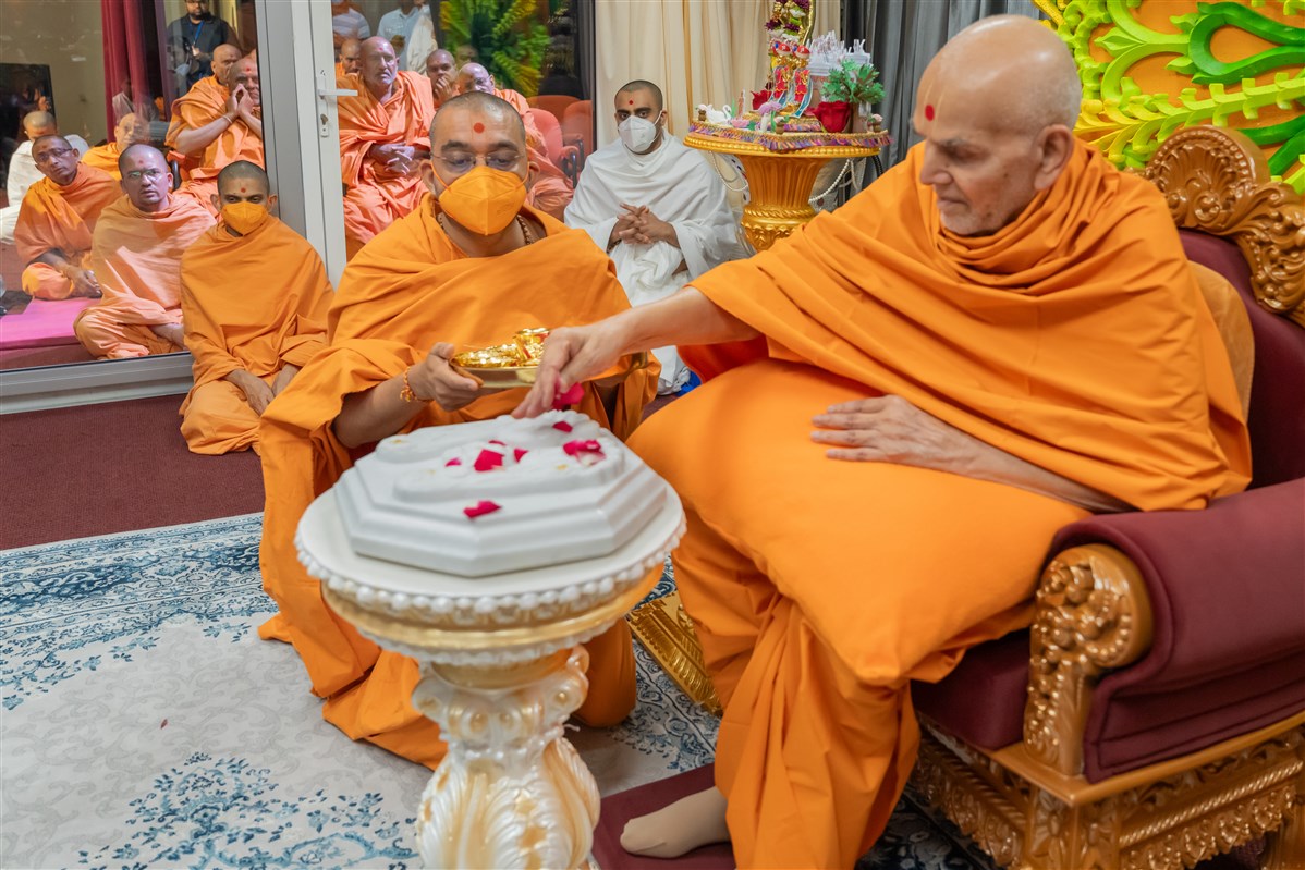 Swamishri sanctifies the marble replica of the holy charnarvind (lotus feet) of Bhagwan Swaminarayan