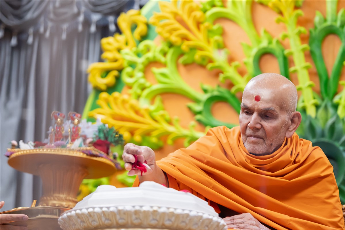 Swamishri sanctifies the marble replica of the holy charnarvind (lotus feet) of Bhagwan Swaminarayan