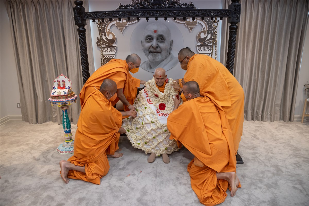 Swamis honour Swamishri with a shawl of flowers