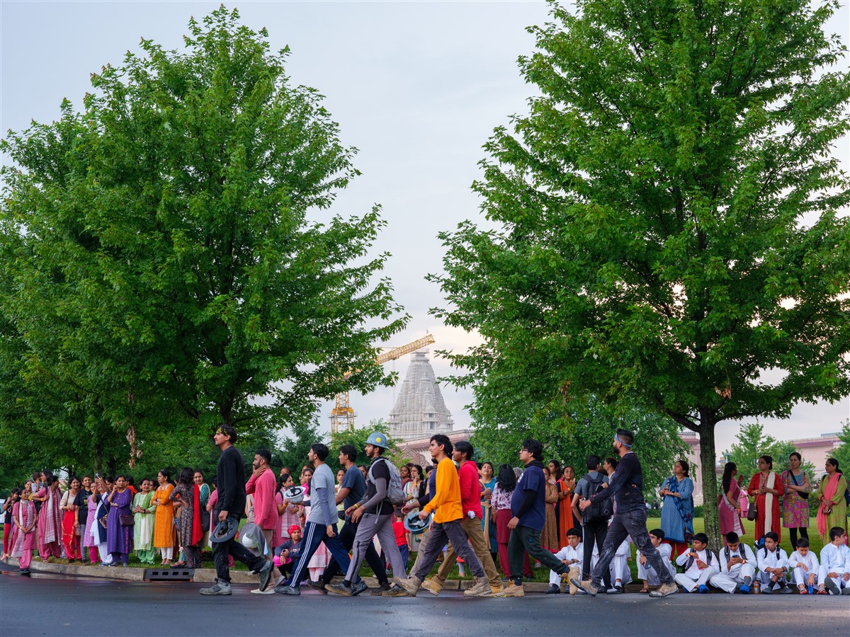 Devotees eagerly line up along the path of Swamishri's arrival to extend a warm welcome to him