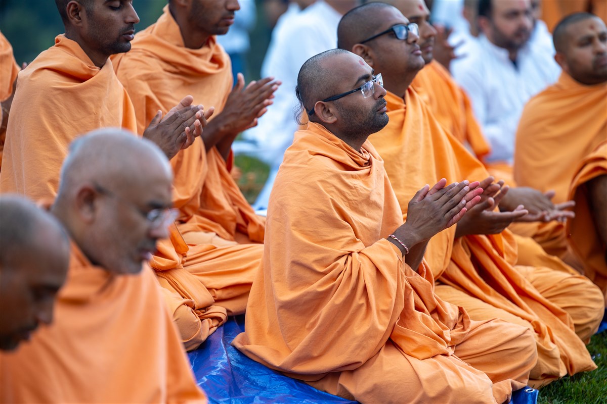 Swamis engrossed in prayers as Swamishri sanctifies the charnarvind
