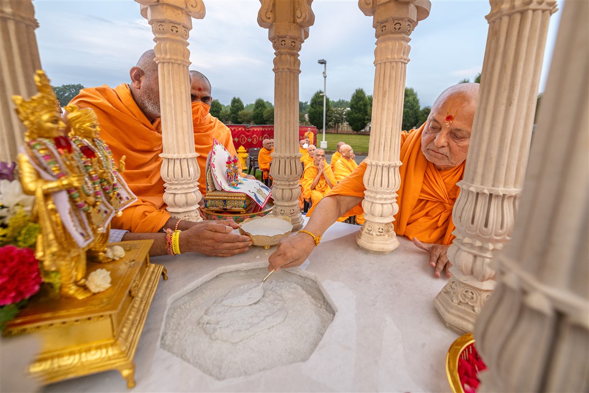 Sadguru Ishwarcharandas Swami pours cement to install the charnarvind
