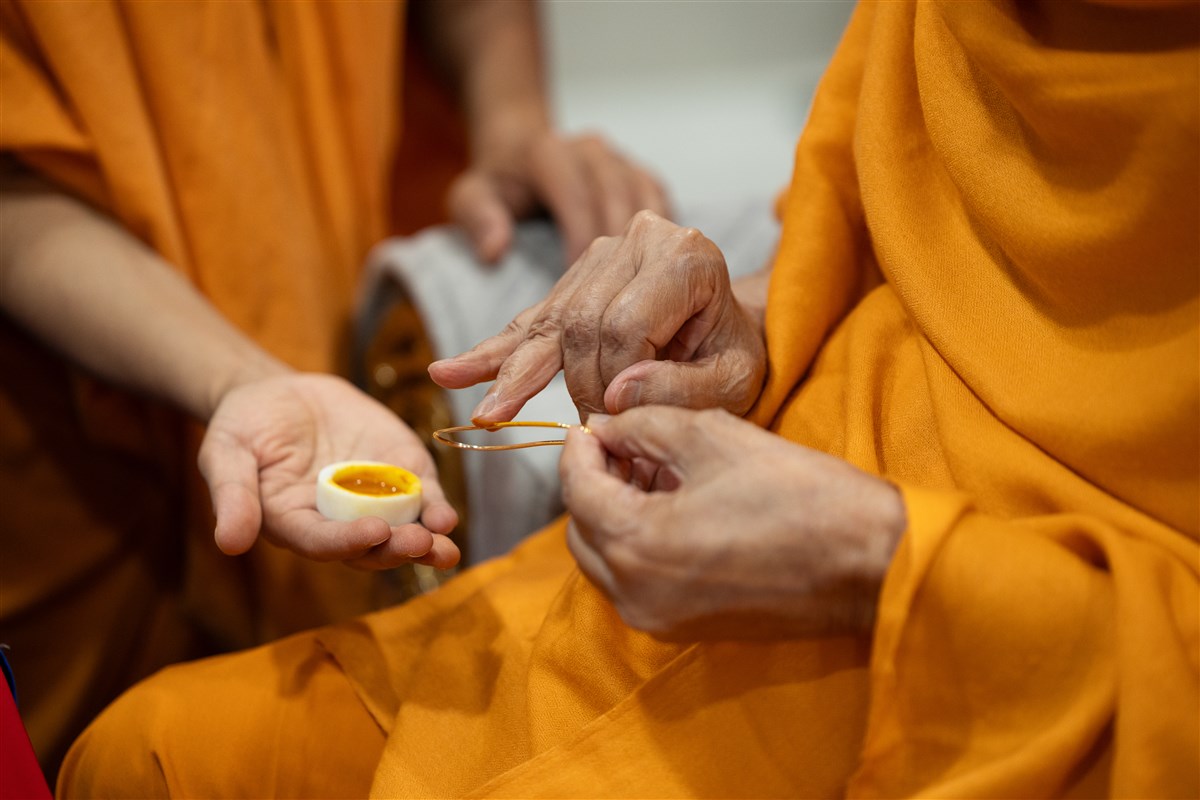 Swamishri commences his morning puja by applying sandalwood paste for the tilak