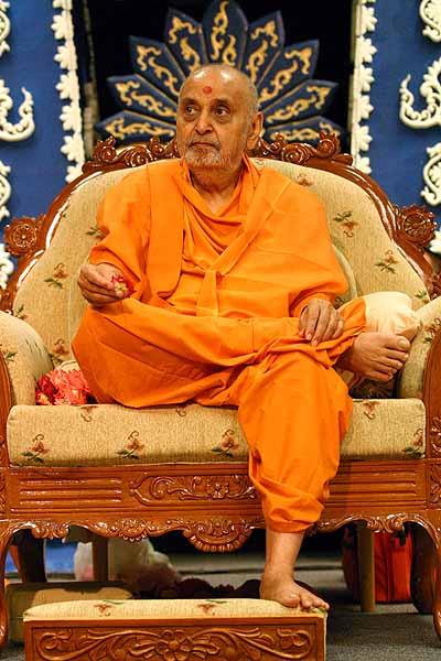 Swamishri with a flower in hand at the end of his morning pooja 