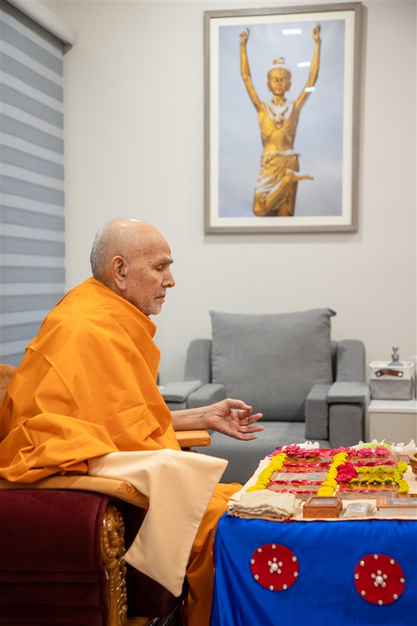 Swamishri, with eyes closed, chants the Swaminarayan mantra