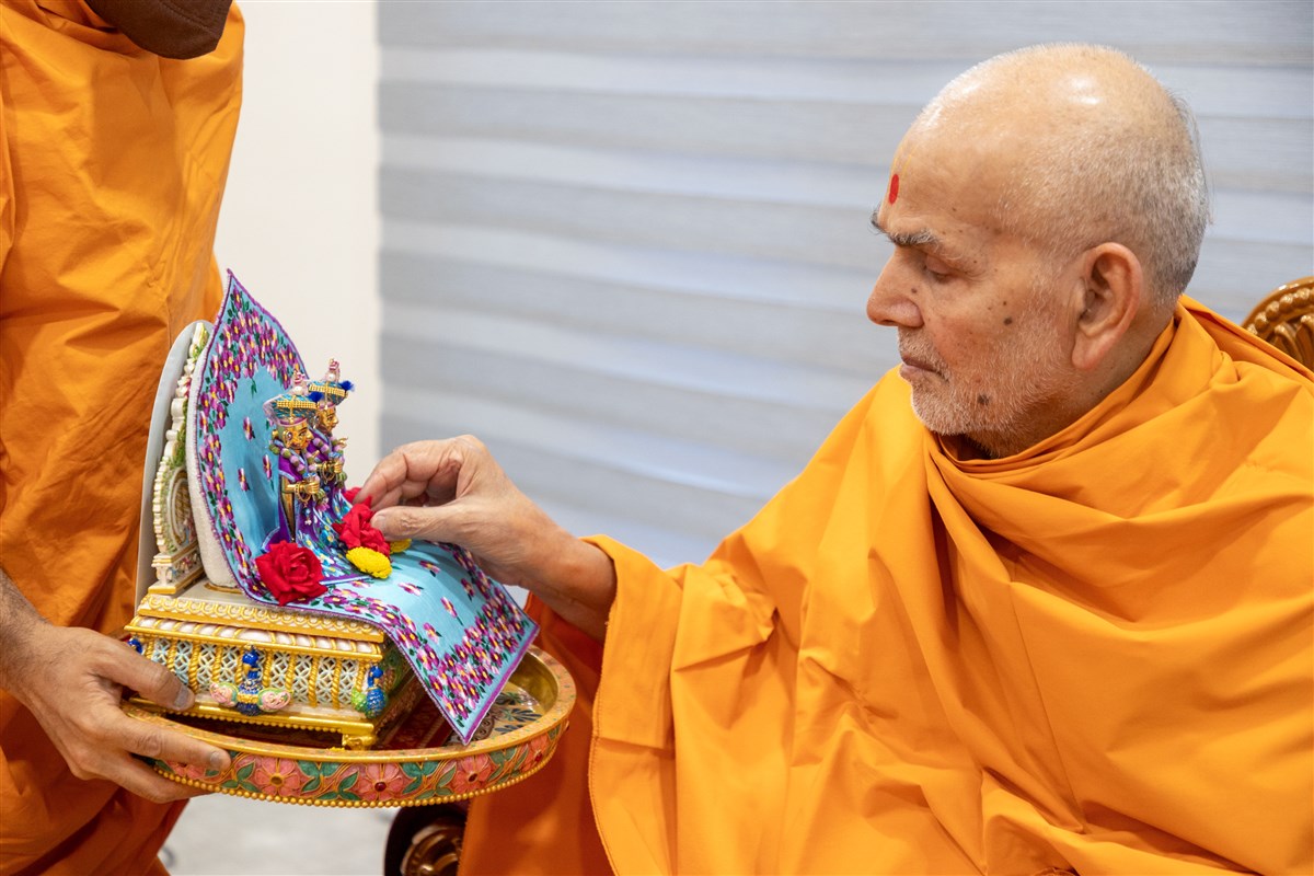 Swamishri offers Shri Harikrishna Maharaj and Shri Gunatitanand Swami flowers as a gesture of surrender, respect, and devotion