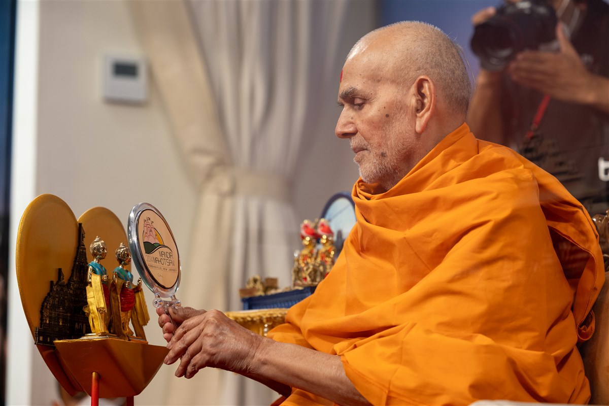 Swamishri consecrates the murtis during the interactive session using the same mirror used by Pramukh Swami Maharaj in 2014