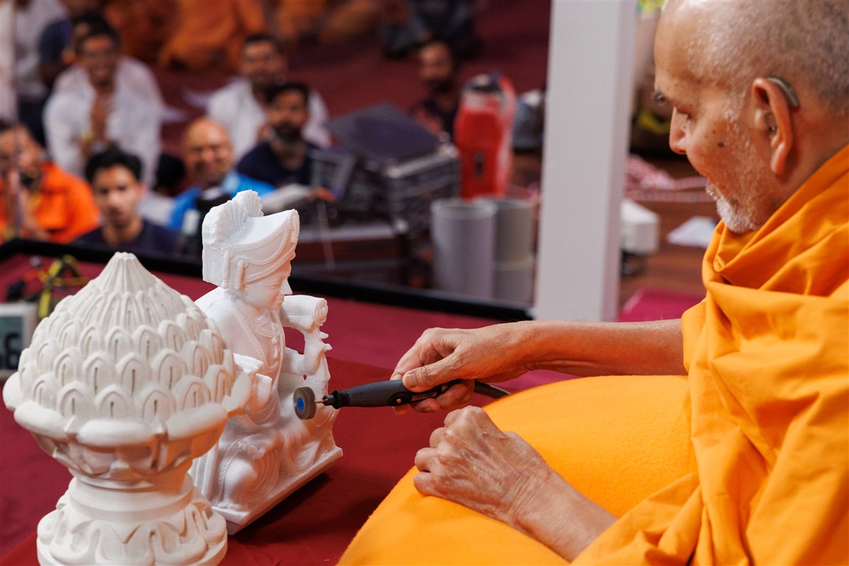 Swamishri gives the finishing touches to a murti