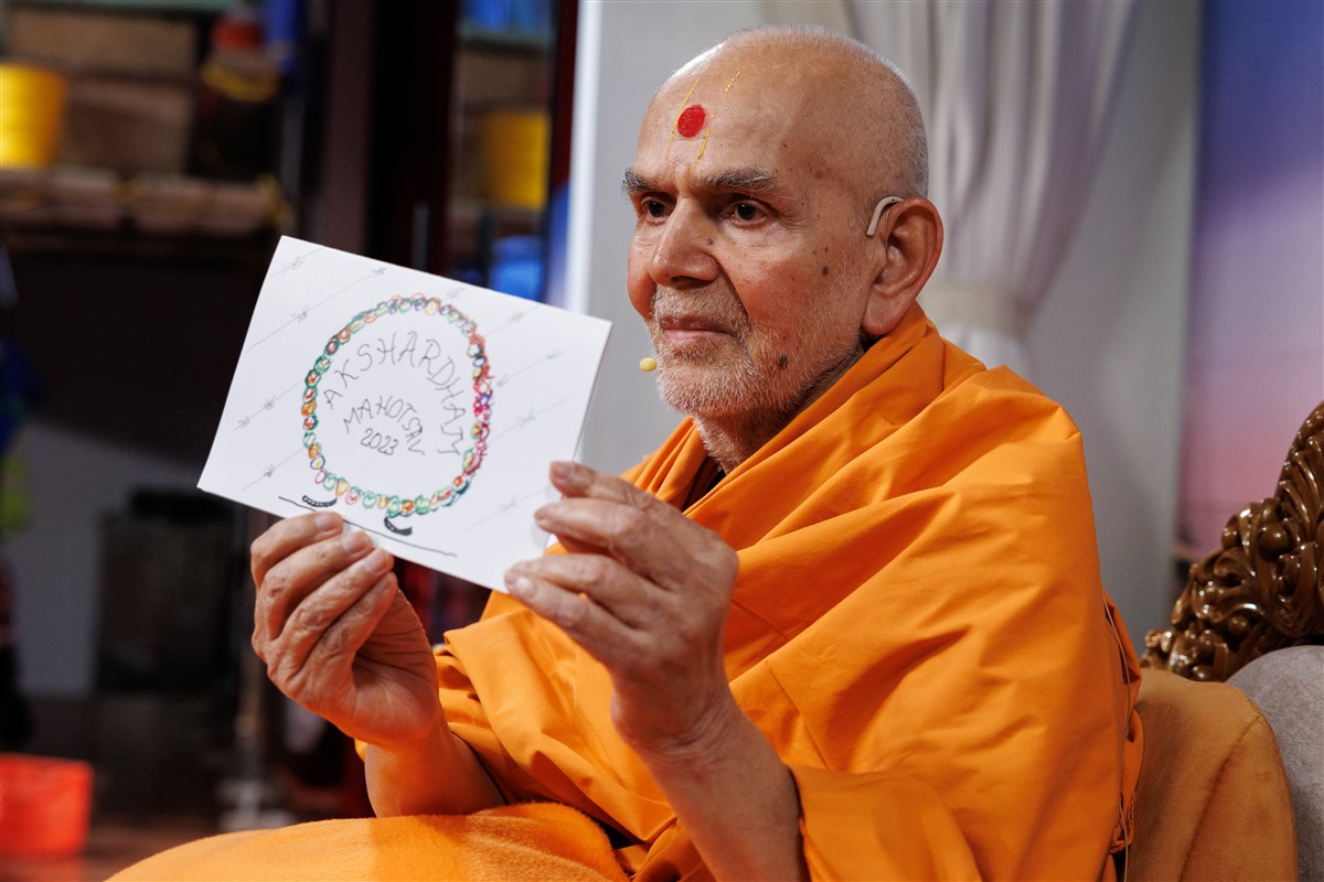 Swamishri displays a special card he created for the volunteers