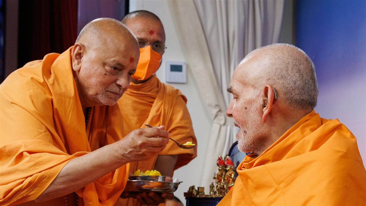 Sadguru Ishwarcharandas Swami offers shiro (traditional sweet) to Swamishri