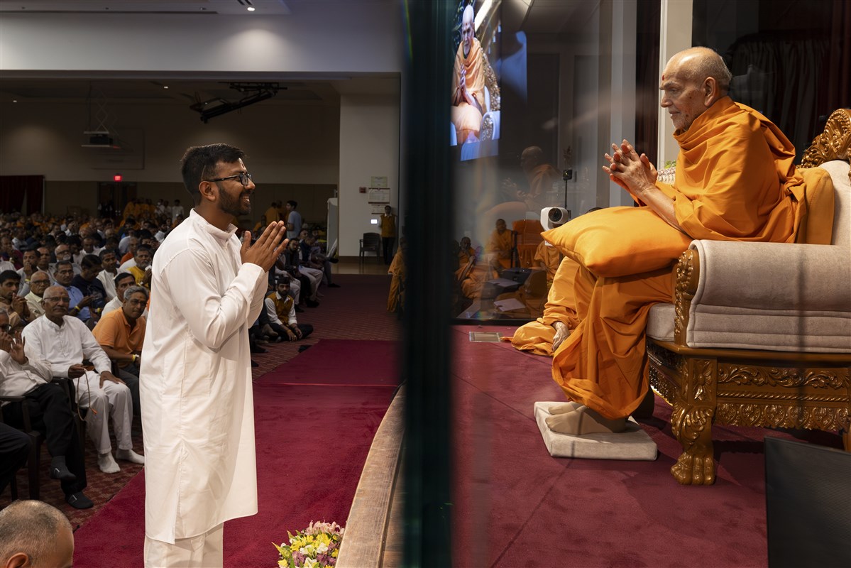 A volunteer receives close darshan of Swamishri