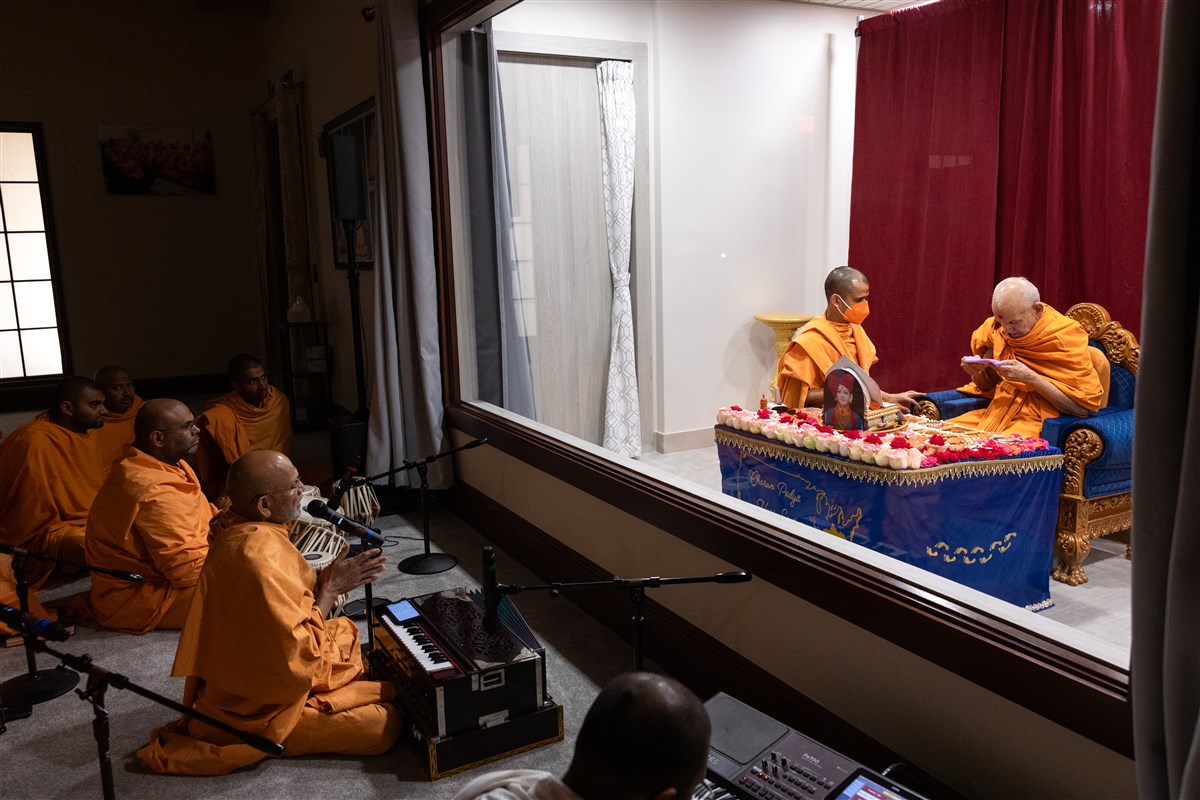 Swamis present kirtan bhakti during Swamishri's puja