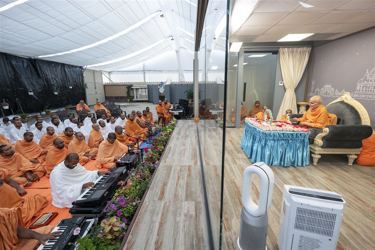 Swamis sing kirtans while Swamishri performs his puja