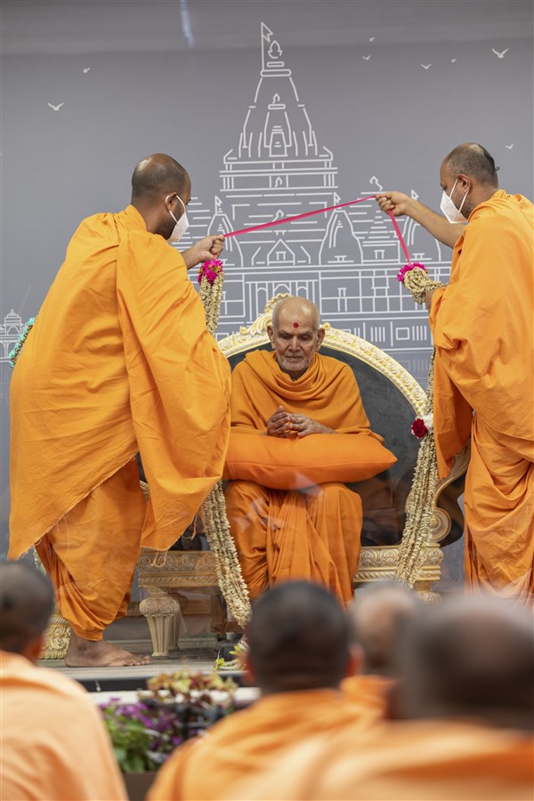 Swamis presents a garland to Swamishri