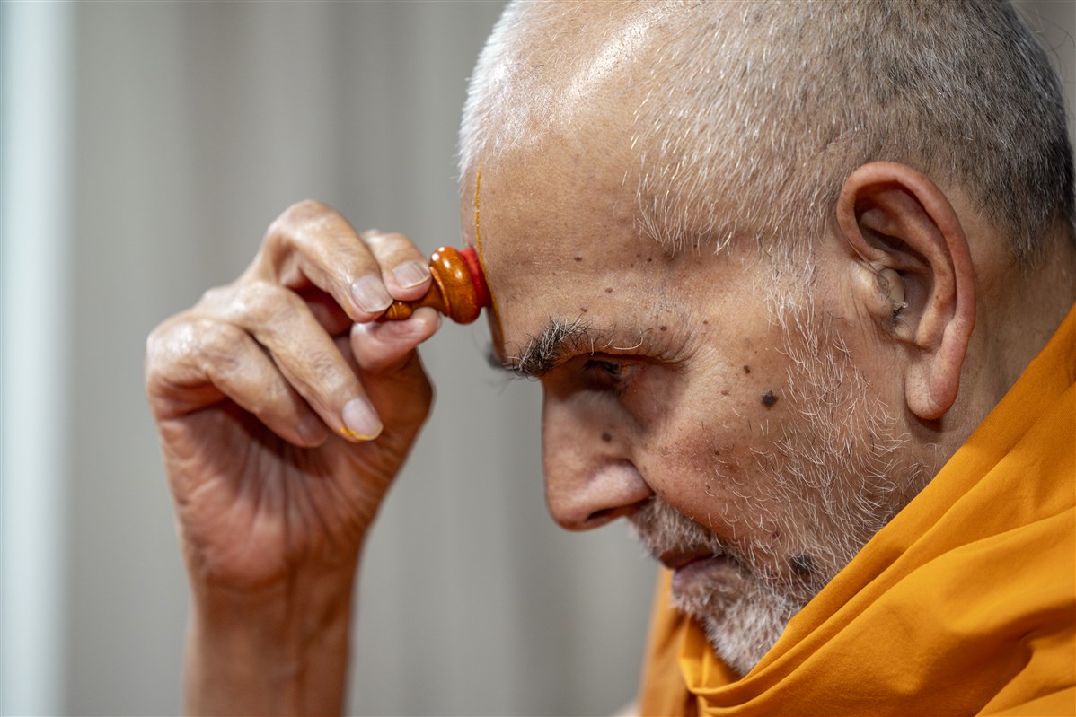 Swamishri applies a chanlo on his forehead