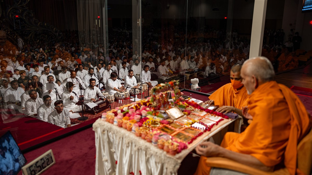 Youths offer kirtan bhakti during Swamishri's puja