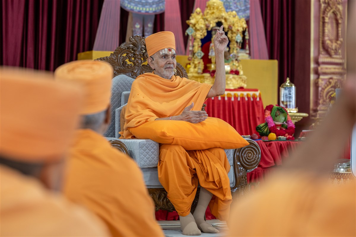 Swamishri gestures during Sadguru Ishwarcharandas Swami's speech