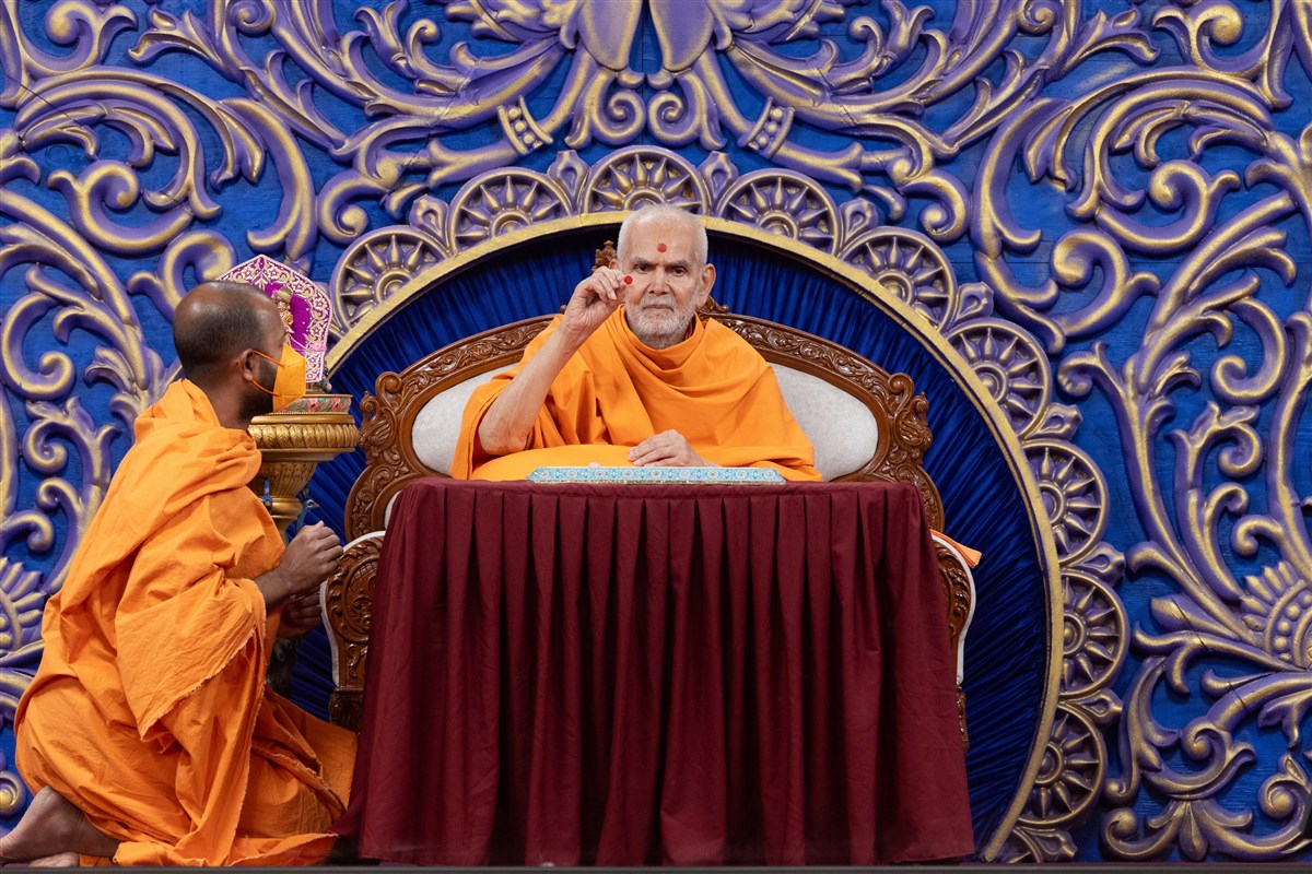 Swamishri applies chandlo to all during the assembly