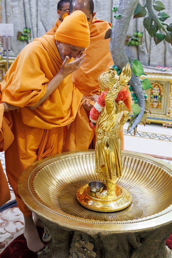 Swamishri reverentially touches the holy charnarvind of Shri Ghanshyam Maharaj