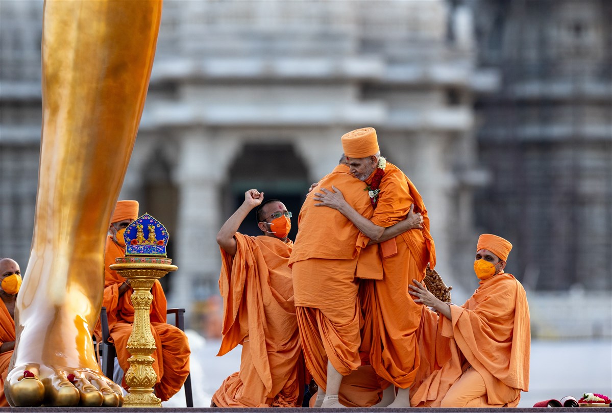 Overflowing with joy, Swamishri spontaneously embraces Sadguru Ishwarcharandas Swami