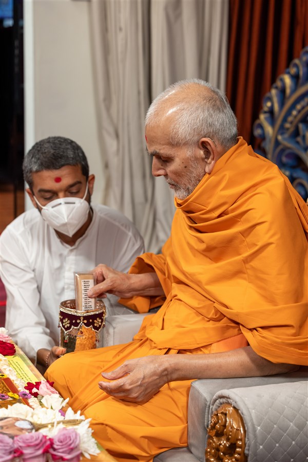 Swamishri sanctifies water with the holy relics of Bhagwan Swaminarayan and the Guru Parampara