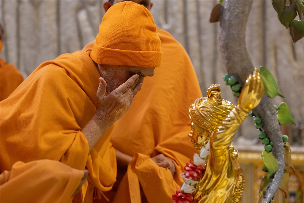 Swamishri touches his eyes after touching the feet of Shri Ghanshyam Maharaj
