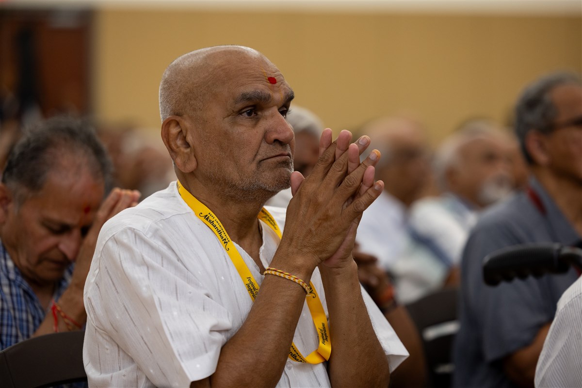 A devotee greets Swamishri with folded hands