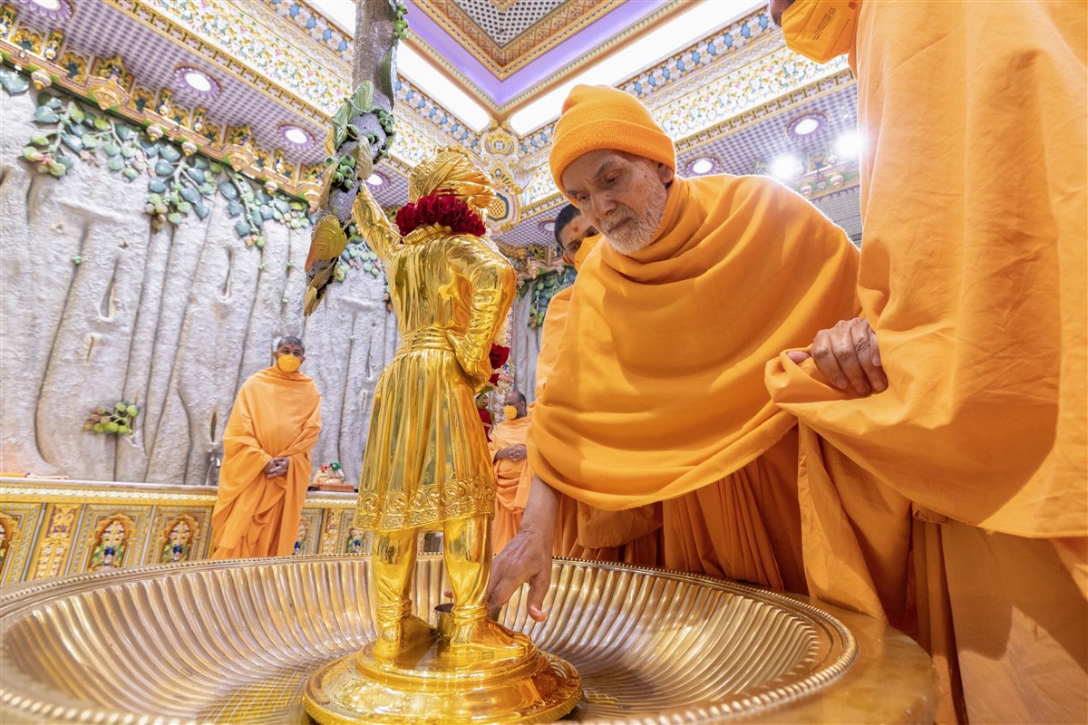 Swamishri touches the feet of Shri Ghanshyam Maharaj