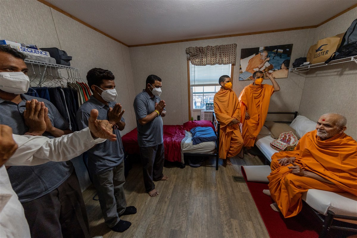 A group of volunteers receive a surprise darshan of Swamishri at their accommodations