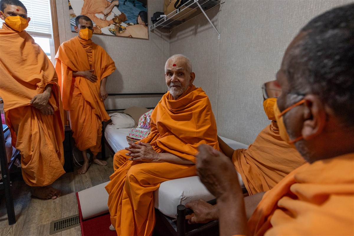 Swamishri listens to swamis describe volunteers’ accommodations