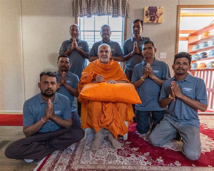 Swamishri joyfully joins a group photo with volunteers