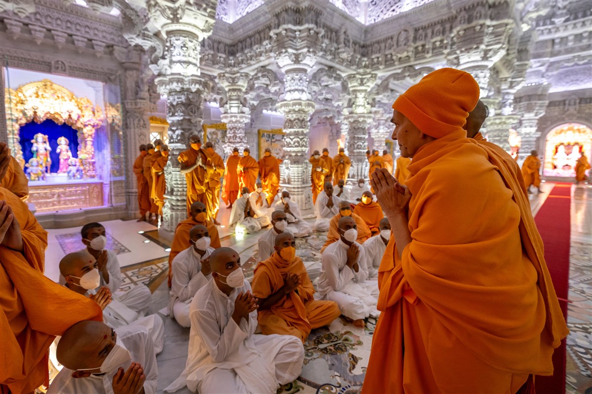 Swamishri acknowledges  and greets swamis and sadhaks