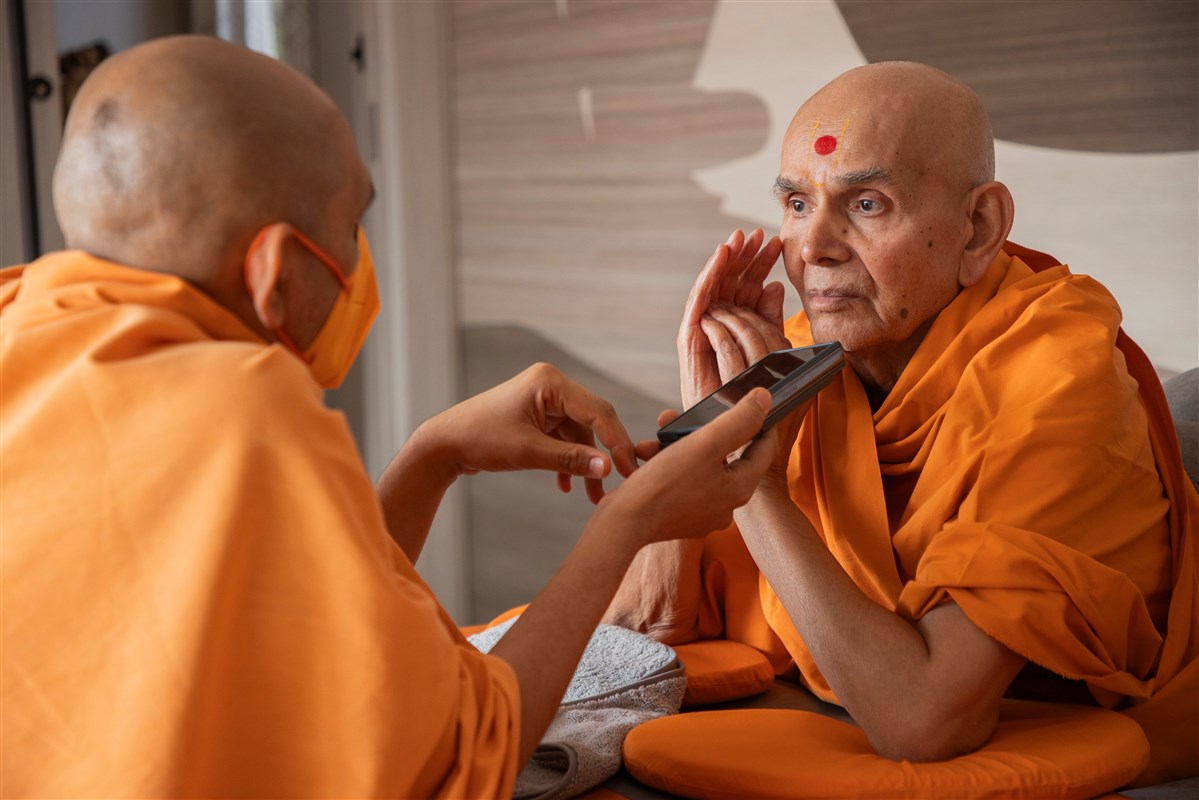 Swamishri listens attentively during a phone conversation