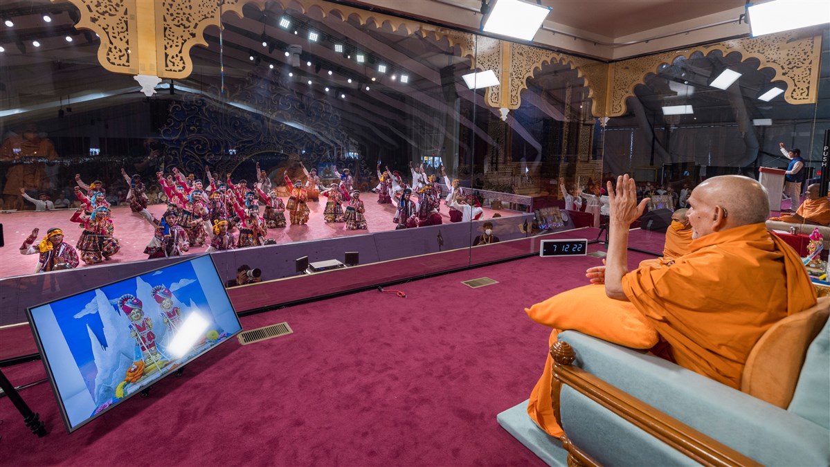 Swamishri gestures to the youths that participated in the cultural dance