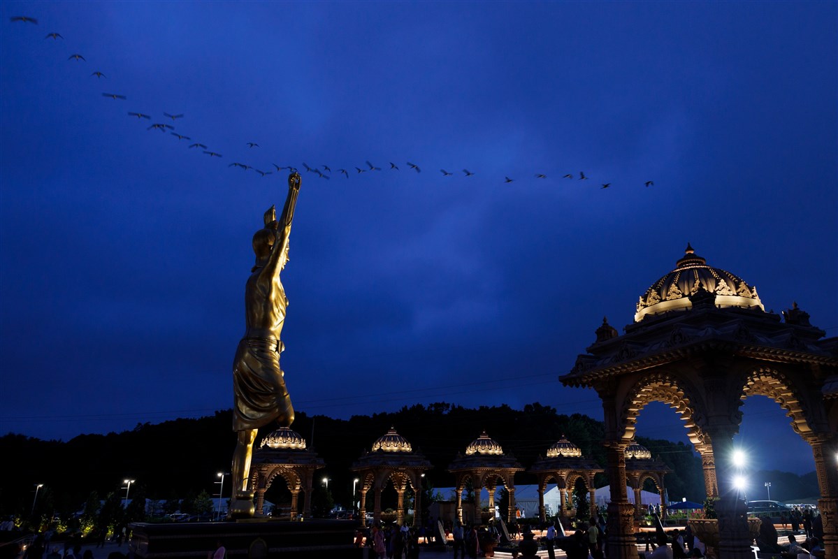 Silhouetted birds across the twilight blue with the serene Tapomurti Shri Nilkanth Varni