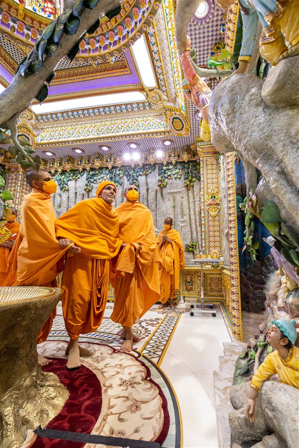 Swamishri looks at the depiction of Ghanshyam Maharaj and his childhood friends while doing pradakshina